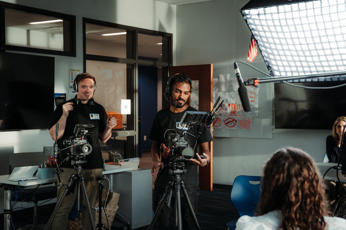 Two camera operators setting up a classroom interview